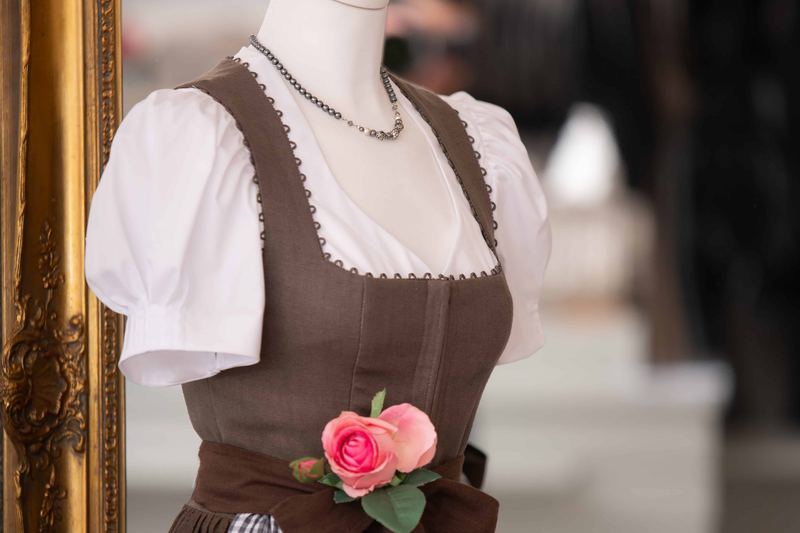 Braunes Dirndl mit weißer Trachtenbluse und karierter Schürze aus der Sportalm Waltner in Nesselwang
