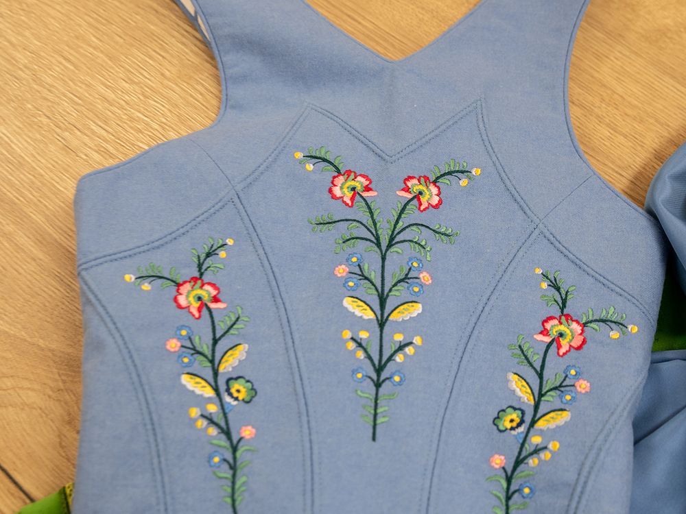 Hellblaues Trachtenmieder mit handgestickten Blumenmotiven, aufgewertet im Maßatelier der Sportalm Waltner in Nesselwang
